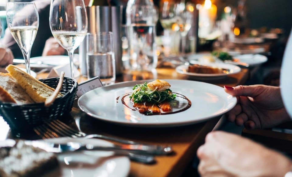 A long table of guests mid-service, glasses poured