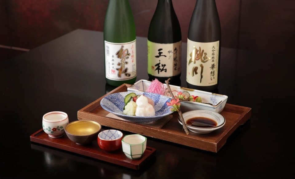 Sake bottles and small plates arranged on a dark table
